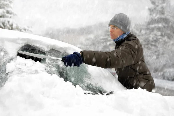 Man removes snow from his car