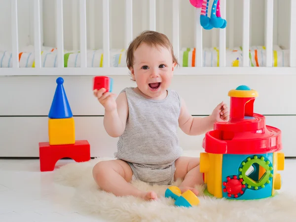 Baby girl playing with educational toy in nursery