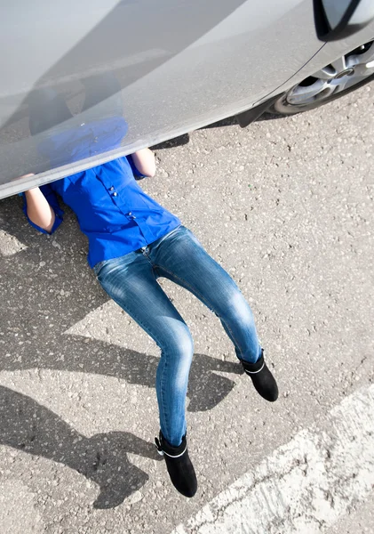 Woman laying under her car