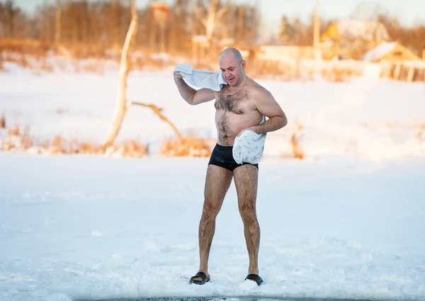 Man wipes towel after swimming in  freezing