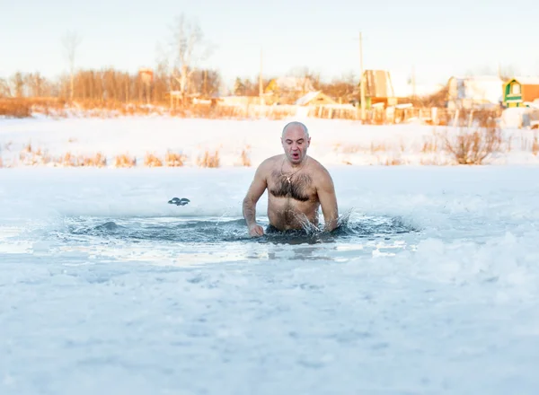 Winter swimming. Man in  ice-hole