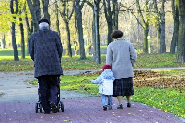 Grandparents and grandchild at the autumn walk
