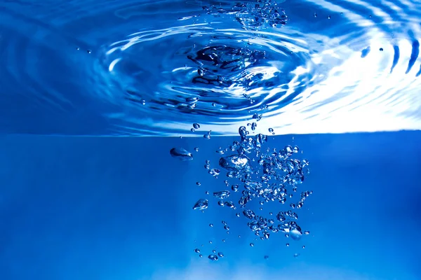 Bubbles and drops under the blue water splash background