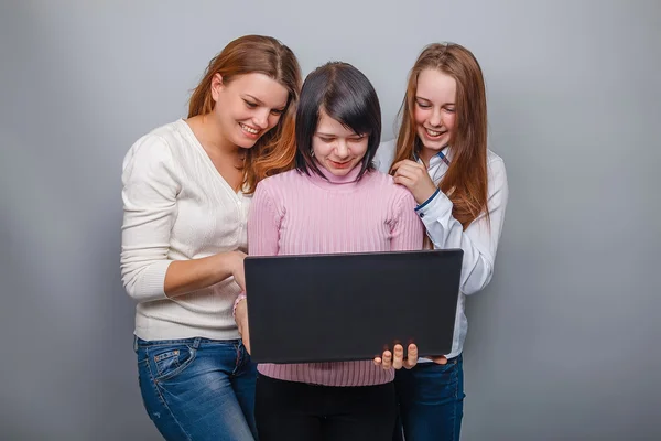 Three girls looking European appearance in computer laughing on