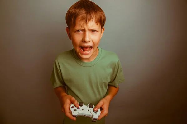 Teen boy screaming open mouth holds emotions game joystick on a