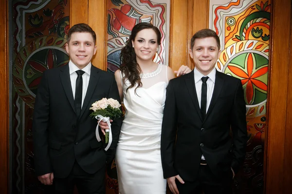 Portrait of the groom with the bride and the brother of the groom of the twin