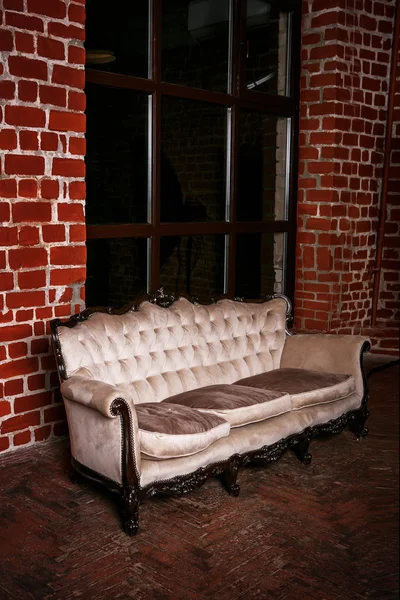 Living room with beige sofa on the  red brick wall