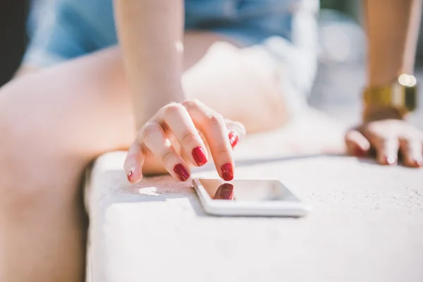 Woman tapping the screen of a smart phone