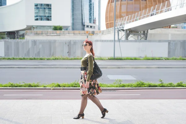 Redhead girl strolling in city