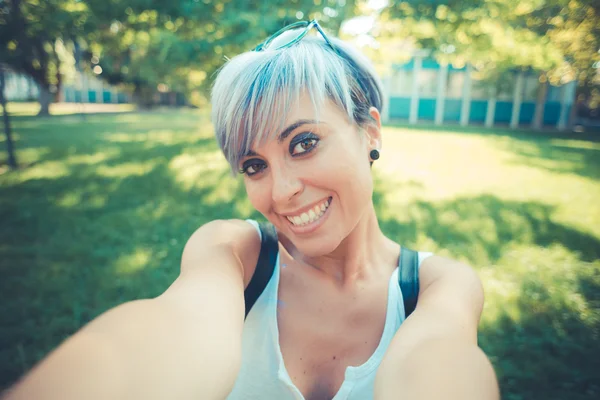 Young beautiful short blue hair hipster woman selfie