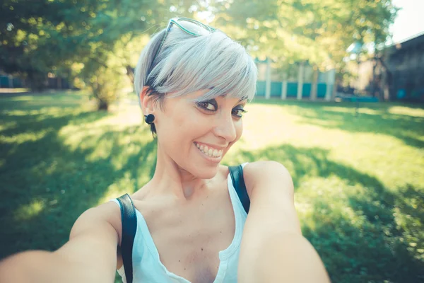 Young beautiful short blue hair hipster woman selfie