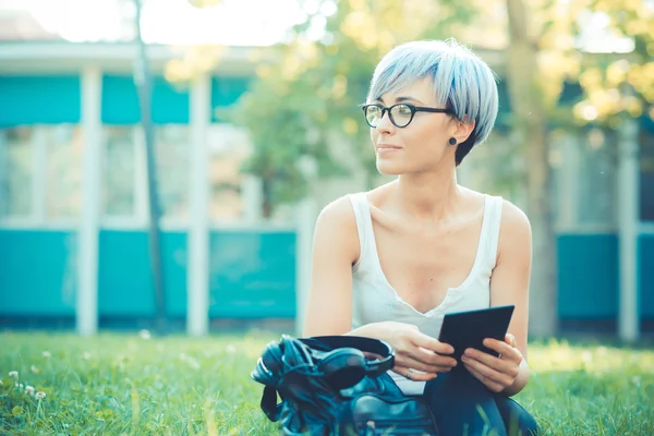 Young beautiful short blue hair hipster woman using tablet