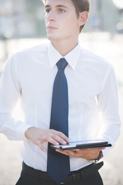 Young handsome elegant blonde model man using tablet