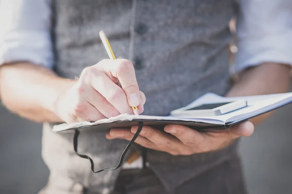 Hands writing on diary