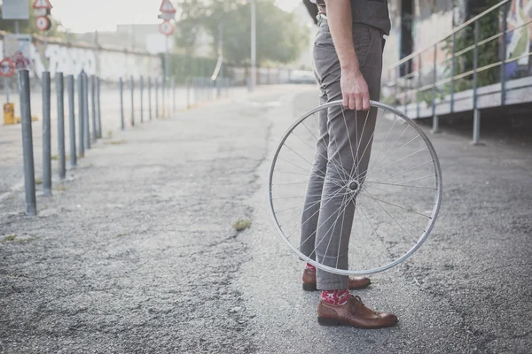 Man holding old bicycle wheel