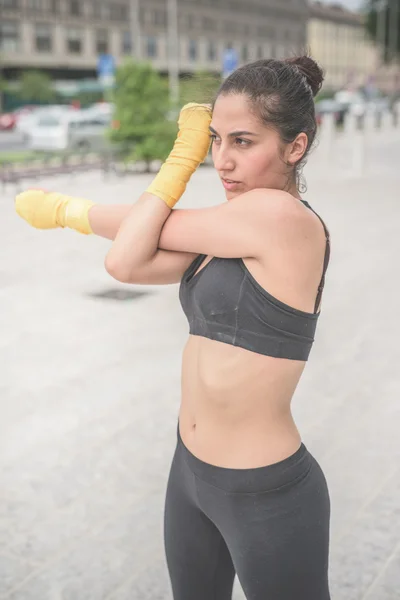 Sportive woman stretching her arms