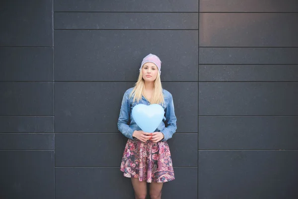 Blonde girl with a hearted balloon