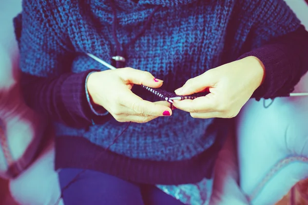 Woman knitting with knitting needles