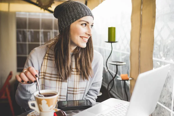 Woman sitting in a bar working with laptop