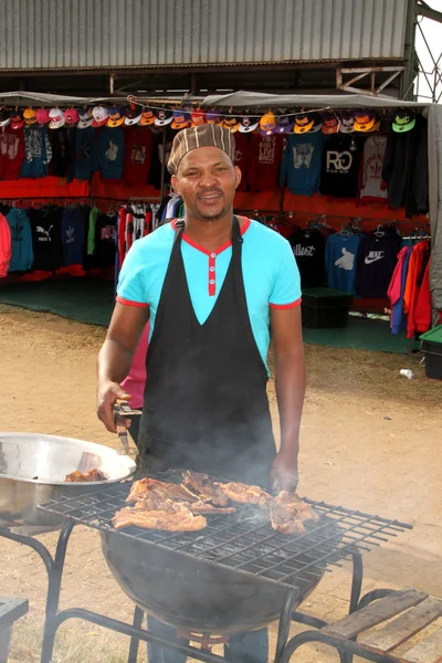 African man busy with barbecue