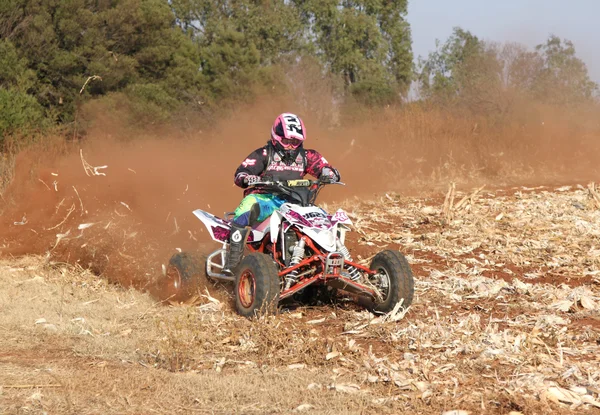 Quad Bike kicking up trail of dust on sand track during rally ra