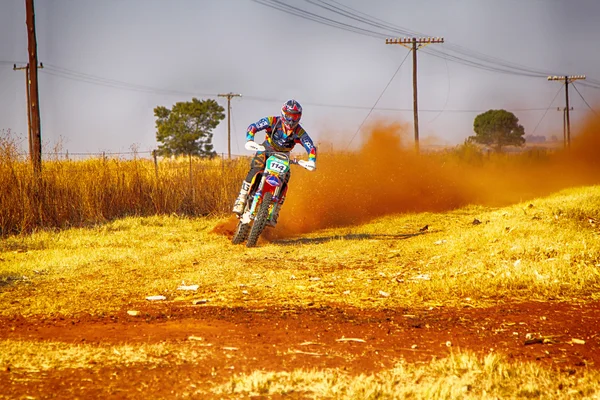 HD - Motorbike kicking up trail of dust on sand track during ral