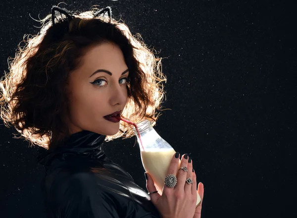 Portrait of beautiful fashion woman drinking milk from the bottl
