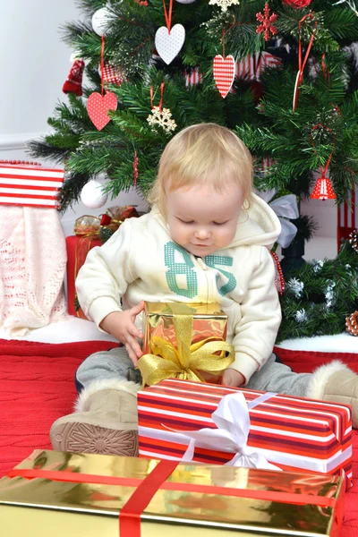 Child baby toddler kid sitting under decorated christmas tree pr