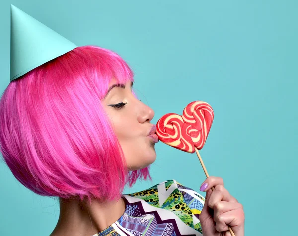 Beautiful funny fashion cheerful woman in hot pink party wig eat