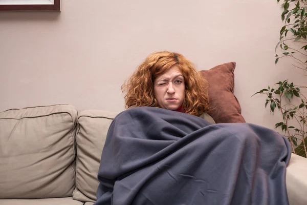 Tired woman having a cold and resting on sofa