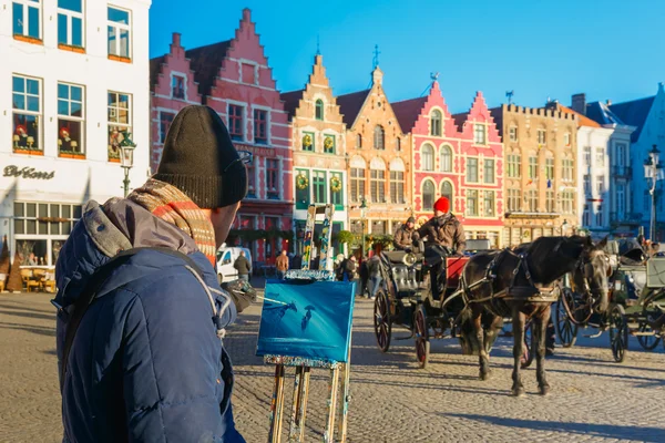 Street artist paints a Horse carriage of Brugge Christmas