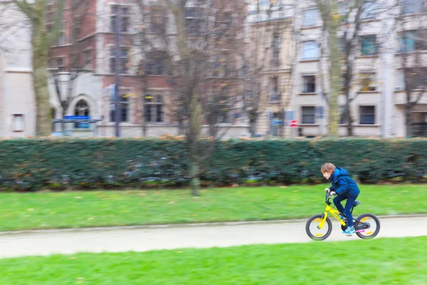 Young sporty boy rides a bicycle on Paris street, France
