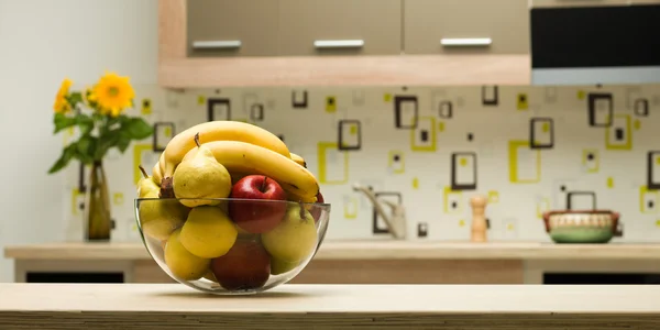 Bowl with healthy fruits in kitchen