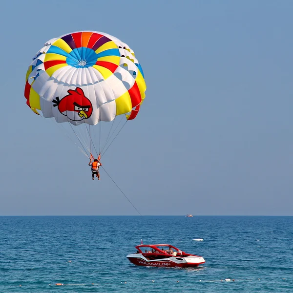 Parasailing in a blue sky.