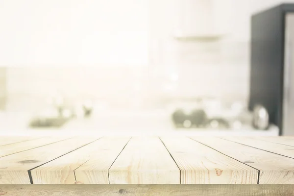 Wooden table over blured kitchen interior background