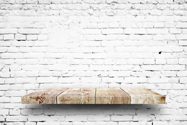 Wooden shelf on white brick wall