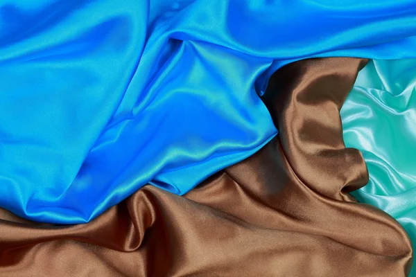 Blue and brown and light green silk satin cloth of wavy folds te