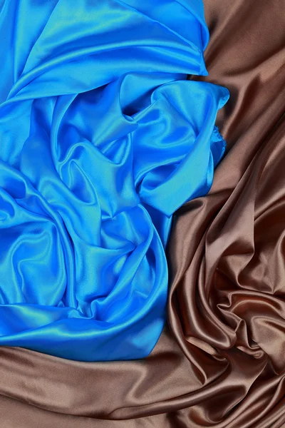 Blue and brown silk satin cloth of wavy folds texture background
