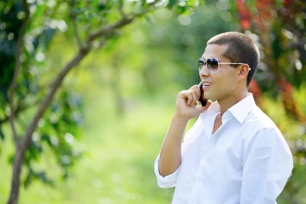 Young smiling man talking on a mobile phone