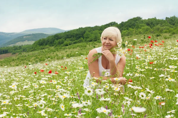 Senior woman having fun on the flower field