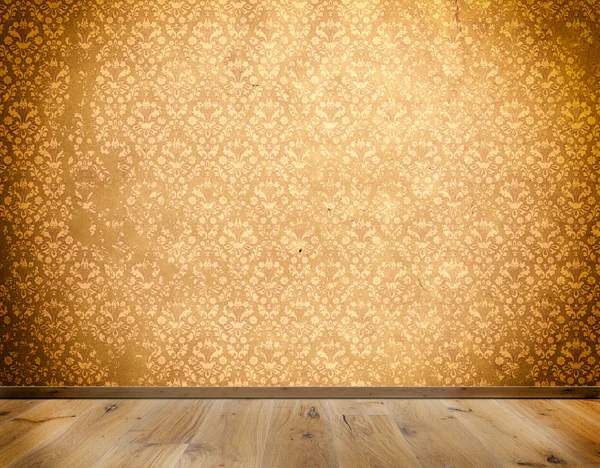 Wall with old-fashioned wallpaper and wooden floor.