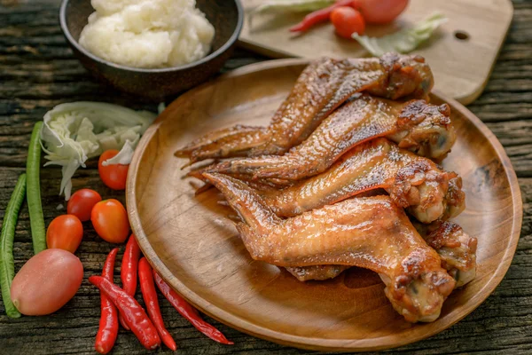 Grilled chicken wings on wooden plate