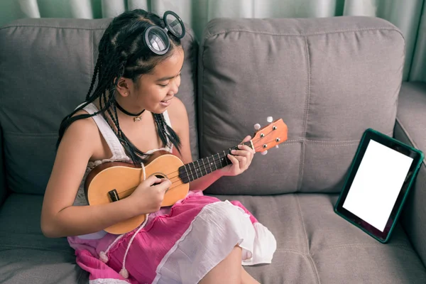 Happy smiling girl learning to play the music