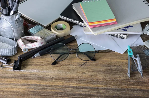 Top view of blank paper and school supplies on the dark wood