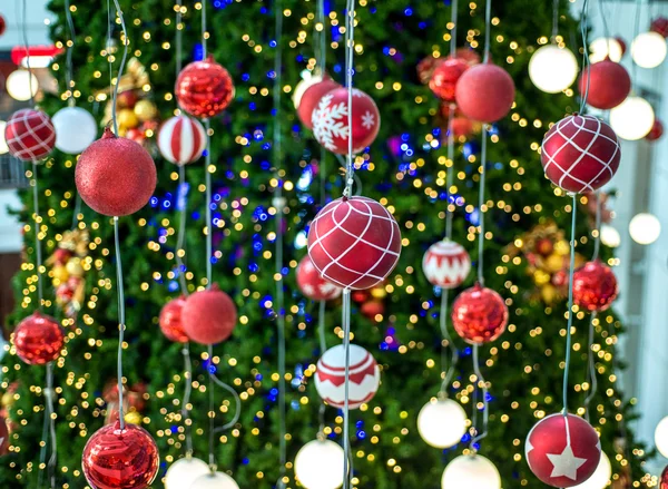 Christmas ball hanging on a Christmas tree with defocused lights