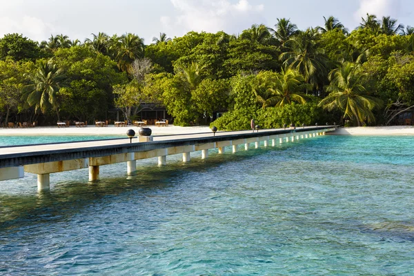 Jetty to a little tropical island in the turquoise indian ocean, maldives, way to a travel destination