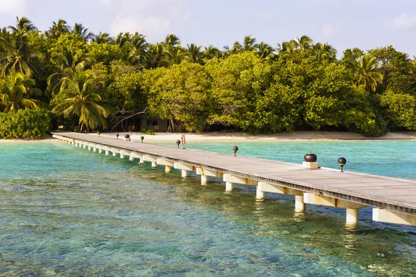 Jetty to a little tropical island in the turquoise indian ocean, maldives, way to a travel destination