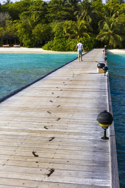 Jetty to a little tropical island in the turquoise indian ocean, maldives, way to a travel destination