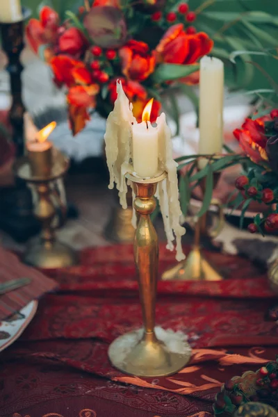 Candels and flowers. Boho decor of table. Photography made in the style of fine art. Stylized like film photo
