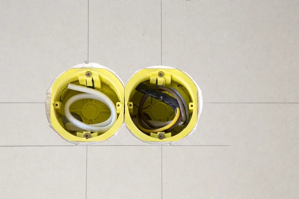 Two yellow electrical sockets installed in drywall